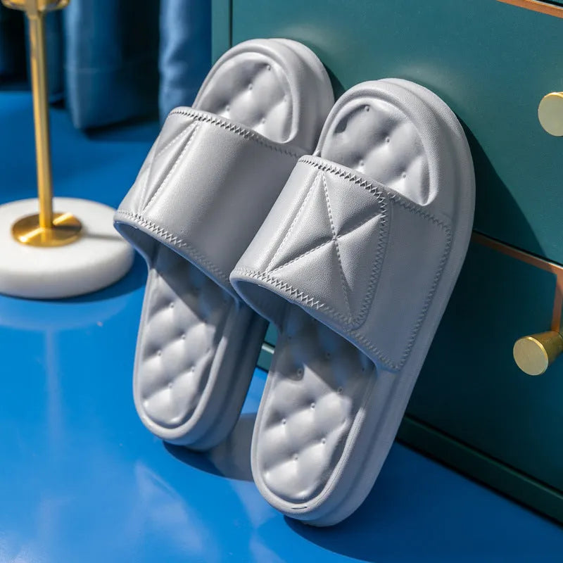 A pair of solid-colour EVA bathroom slippers with a thick, textured sole, shown on a bathroom floor.