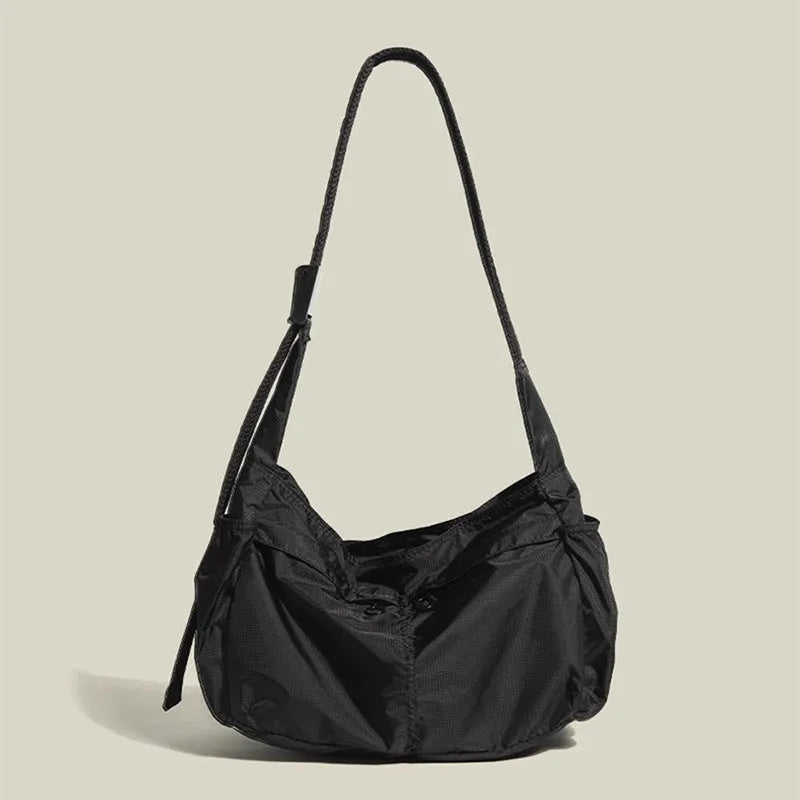 Large black nylon waterproof messenger bag with a single shoulder strap, shown open to reveal internal organisation.