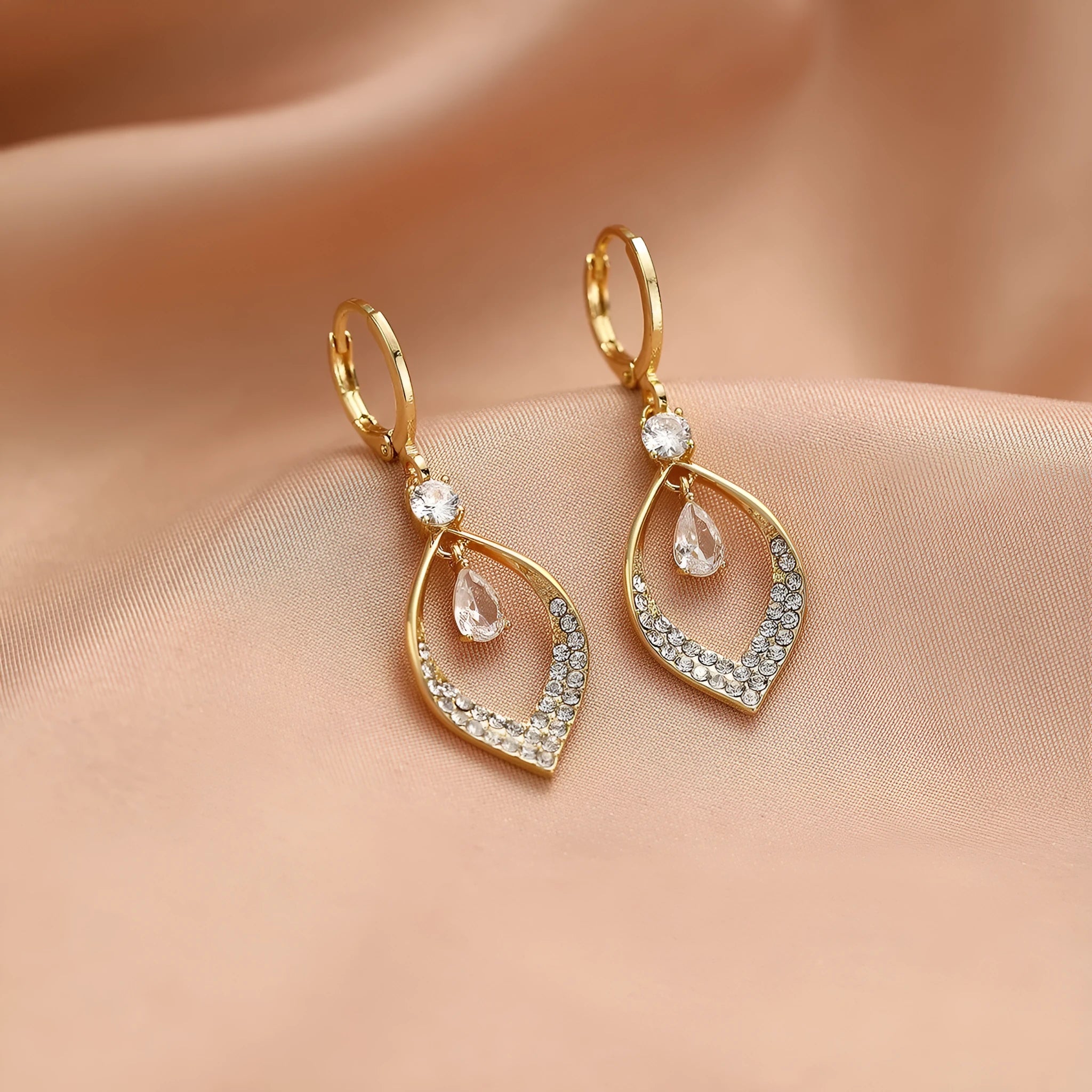 Gold zircon teardrop tassel earrings with electroplated copper construction.