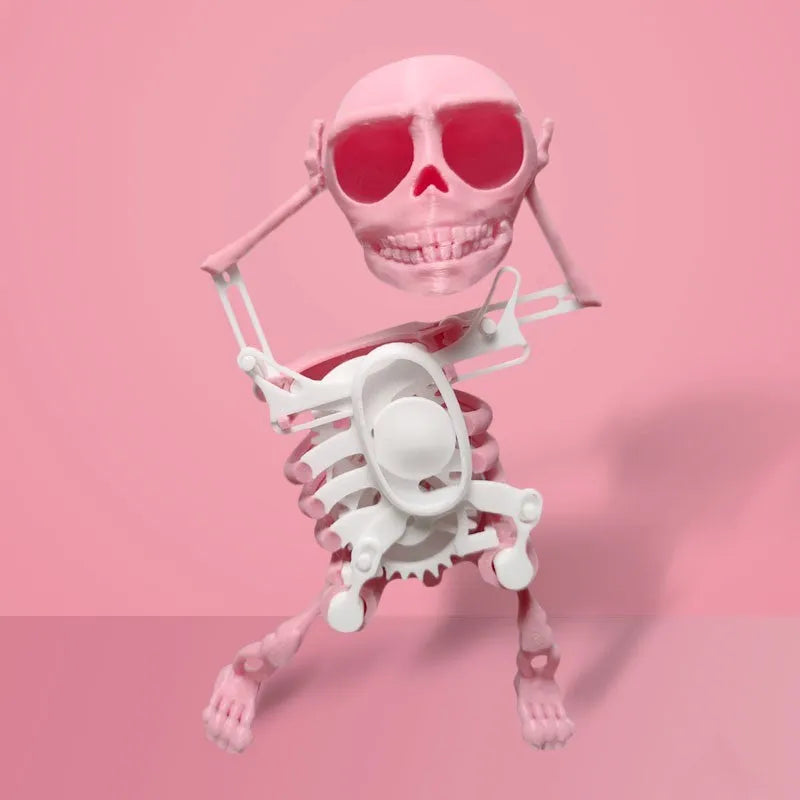 3D printed dancing skeleton gravity toy in pink and white, 22cm tall, on a desk