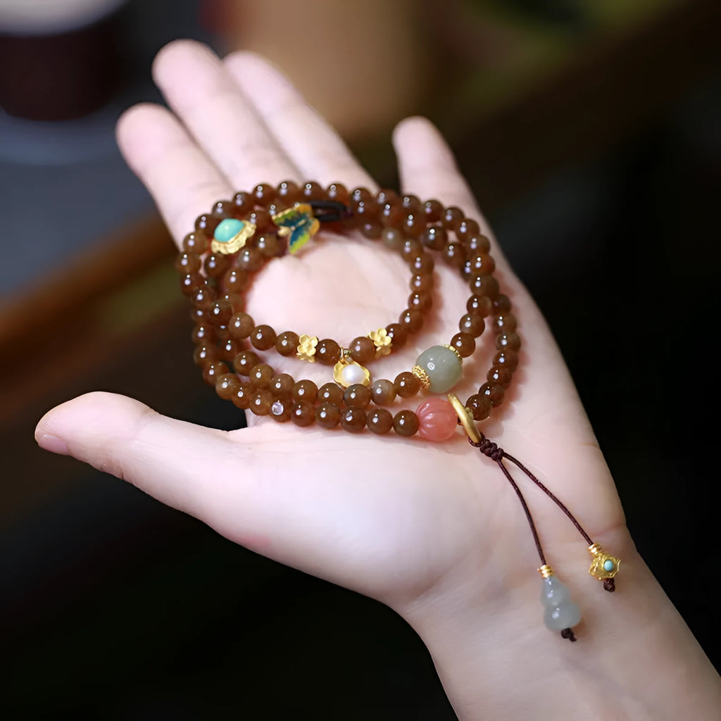 Brown Hetian jade bracelet with three-ring design featuring carved gourd and butterfly charms, silver-plated connectors