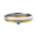 A geometric engraved titanium steel ring with a December birthstone, showcasing gold-tone and steel lettering accents.