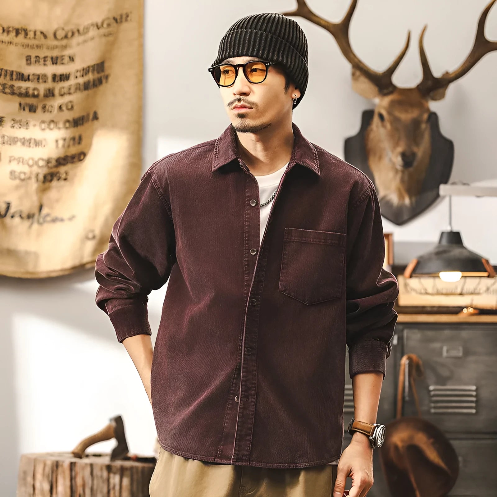A man wearing a loose-fit black corduroy shirt jacket with long sleeves.
