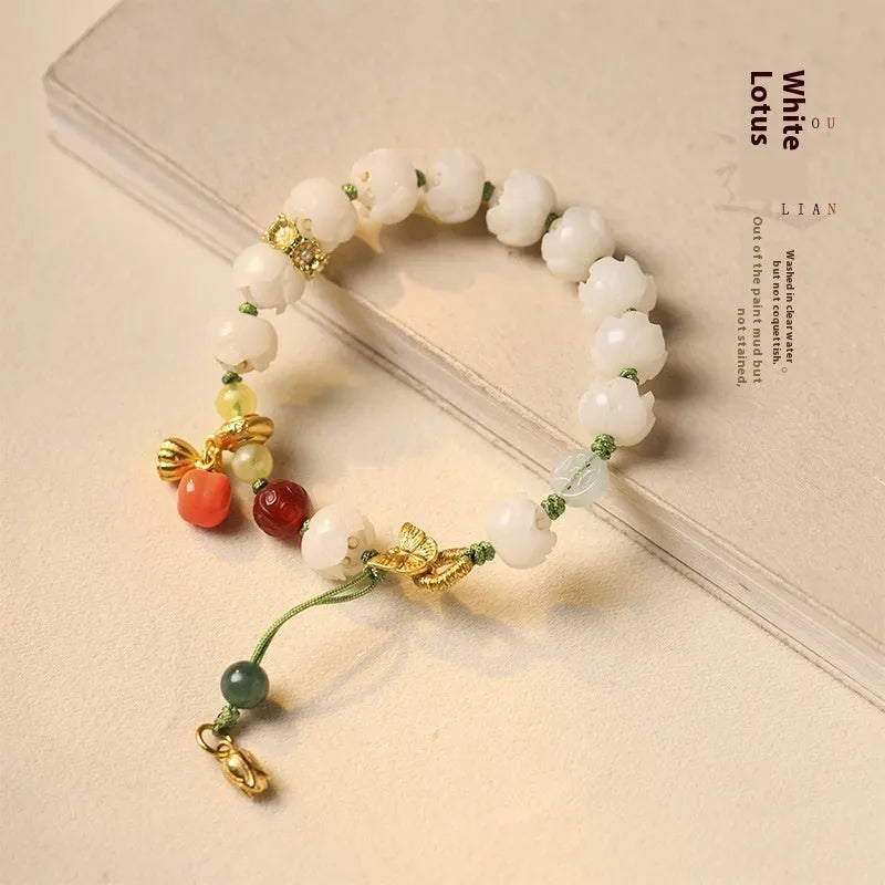 Close-up of a hand-woven white jade Bodhi bracelet with pumpkin and lotus beads on an adjustable rope.