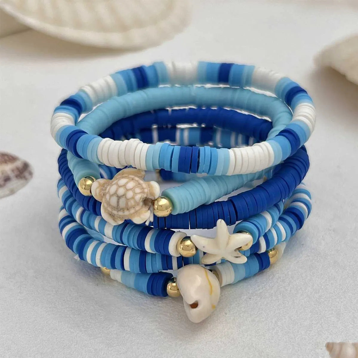 Six polymer clay handmade bracelets with Bohemian blue shells and geometric designs