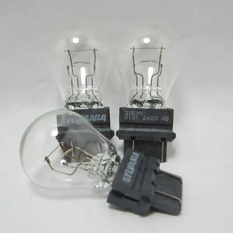 Wagner dual-wire brake light bulb with yellow glass and plastic orientation dot.